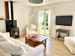 ein Wohnzimmer mit weißen Möbeln und einem Flachbild-TV in der Unterkunft Maison à Castellane in Castellane