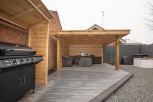a backyard patio with a grill and an outdoor kitchen at Titchfield House in Titchfield