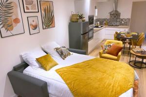 um quarto com uma cama com um cobertor amarelo em Le Val de Cœur em Valence