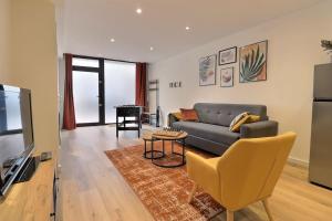 a living room with a couch and a television at Le Val de Cœur in Valence