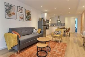 a living room with a couch and a table and a kitchen at Le Val de Cœur in Valence