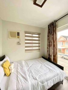a bedroom with a white bed and a window at 4BR Townhouse at PonteFino Residences Batangas City in Batangas City