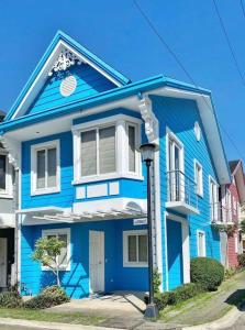 una casa azul con una luz de la calle delante de ella en 4BR Townhouse at PonteFino Residences Batangas City, en Batangas