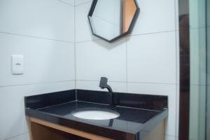 een badkamer met een zwarte wastafel en een spiegel bij Chocolate com pimenta Edifício - Praia do Bessa in João Pessoa
