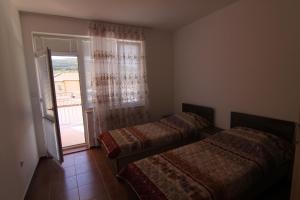 2 Betten in einem Zimmer mit Fenster in der Unterkunft Apartments in Lotos Complex in Kranewo