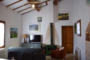 sala de estar con sofá azul y TV en Les Grands Prés des Baronnies en La Roche-sur-le-Buis