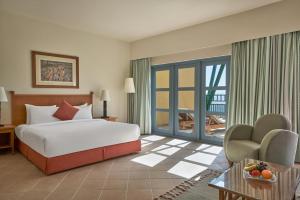 a hotel room with a bed and a balcony at Strand Beach Resort in Taba