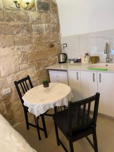 cocina con mesa, 2 sillas y barra en בר יוחאי en Safed