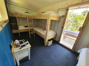 Zimmer mit 2 Etagenbetten und einem Tisch in der Unterkunft Le Camptainer, Glamping Eco Farm Stay in Grand Sable