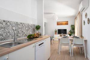 una cucina con lavandino e tavolo con sedie di NEW! Apartment SUNSET 1, Pool, AC, BBQ, Wifi, Cala D'or, Mallorca a Cacla D'or