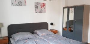 ein Bett mit zwei Kissen in einem Schlafzimmer mit einem Spiegel in der Unterkunft Ilmenauer Ferienwohnung in Ilmenau
