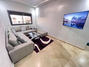 a living room with a couch and a tv on the wall at Beachfront Apartment in Imi Mikki