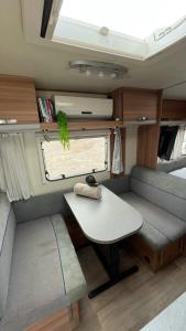 a small table and chair in an rv at שלווה בים - צימר ים המלח, deadsea in Ovnat