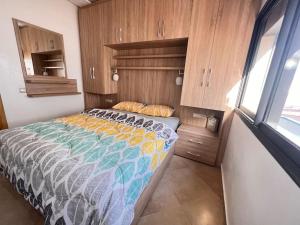a bedroom with a bed and wooden cabinets at Beachfront Apartment in Imi Mikki