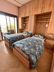 a bedroom with two beds and a large window at Beachfront Apartment in Imi Mikki