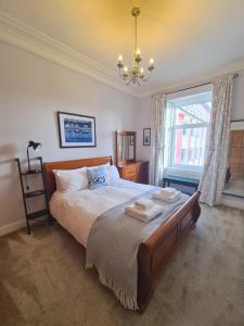 a bedroom with a large bed with two towels on it at The Editor's Choice, Oban seafront apartment in Oban