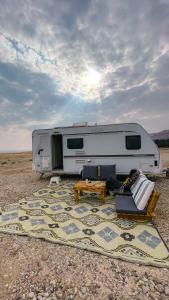 Ein weißer Wohnwagen parkt mitten in der Wüste. in der Unterkunft שלווה בים - צימר ים המלח, deadsea in Ovnat