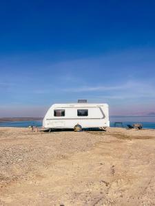 a white trailer sitting on top of a field at שלווה בים - צימר ים המלח, deadsea in Ovnat