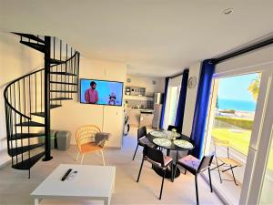 - un salon avec un escalier en colimaçon, une table et des chaises dans l'établissement Oceanfront Duplex with a Rooftop Pool and Terrace, à El Puerto de Santa María