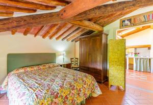 um quarto com uma cama num quarto com tectos em madeira em Borgo Bucciano em San Miniato