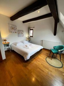 1 dormitorio con 1 cama y 1 silla verde en GITE DES FORGERONS en Dambach-la-Ville