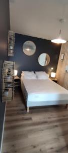 ein Schlafzimmer mit einem weißen Bett und zwei Spiegeln in der Unterkunft Studio Bidehegia in Souraïde