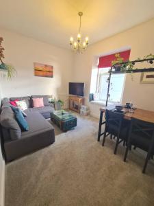 a living room with a couch and a table at The Editor's Choice, Oban seafront apartment in Oban