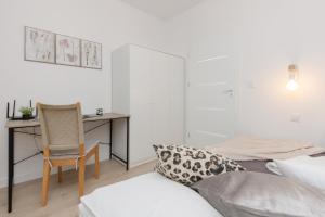 a bedroom with a bed and a desk and a chair at Warsaw Piaseczno Peaceful Apartment Cichej Łąki by Noclegi Renters in Piaseczno