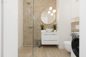 a bathroom with a shower and a toilet and a mirror at Warsaw Piaseczno Peaceful Apartment Cichej Łąki by Noclegi Renters in Piaseczno +12 photos