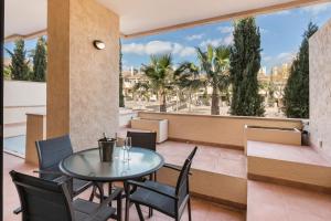 un patio con tavolo, sedie e ampia finestra di Plaza Malta Oasis 2 Bajo a Fuente Alamo