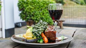 a plate of food and a glass of wine on a table at The Boathouse in Seaview