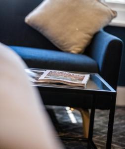 a coffee table with a blue couch and a pillow at No5 Durley Road - Contemporary serviced rooms and suites - no food available in Bournemouth