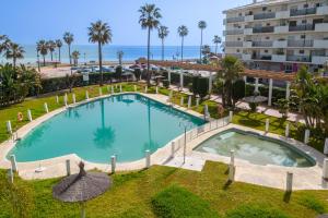 an overhead view of a swimming pool with the ocean in the background at 28 Rooftop apartment close to the beach Sabinillas in San Luis de Sabinillas