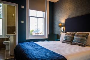 um quarto com uma cama grande e uma janela em No5 Durley Road - Contemporary serviced rooms and suites - no food available em Bournemouth