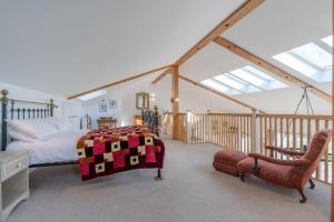 1 dormitorio con 1 cama con edredón en The Old Barn en Witney