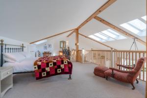 a bedroom with a bed with a quilt on it at The Old Barn in Witney