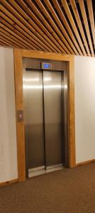 an elevator in a building with a metal door at Hostdomus - Sansicario R21 in Cesana Torinese