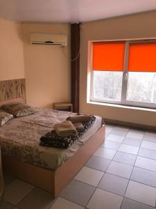 a bedroom with a bed and a large window at Мотель "Євро" in Chernivtsi