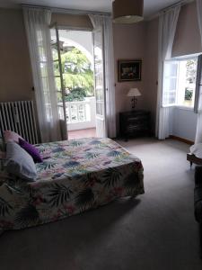 ein Schlafzimmer mit einem Bett und einem großen Fenster in der Unterkunft La maison basque in Sainte-Livrade-sur-Lot