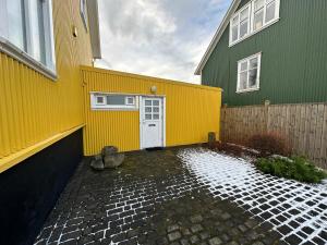 un edificio amarillo y verde con una puerta blanca en An elegant studio apartment in Reykjavik - Great Location en Reikiavik