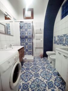 bagno blu e bianco con lavatrice di Il Casadduoglio a Vietri