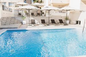una piscina en un hotel con sillas y sombrillas en Nacavi Albir Aparthotel, en Albir