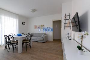 ein Esszimmer und ein Wohnzimmer mit einem Tisch und Stühlen in der Unterkunft Condominio Medusa in Lido di Jesolo