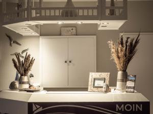 a counter with vases and a cabinet in a room at Garni Hotel & Appartements Nordstrand in Nordstrand