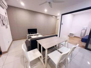 a dining room with a table and white chairs at [Promo] Connected Train 2 Bedroom (ABOVE MALL) 28 in Kuala Lumpur