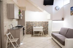 a kitchen and a living room with a couch and a table at Agriturismo Casa Scola in Gragnano
