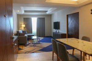 マニラにあるルセント ホテルのテーブルとリビングルームが備わるホテルルームです。
