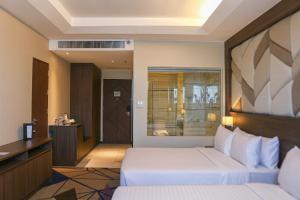 Habitación de hotel con cama y escritorio en Luxent Hotel, en Manila