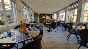 Un restaurante con mesas, sillas y ventanas. en Hôtel Normand Yport non étoilé ambiance familiale, en Yport