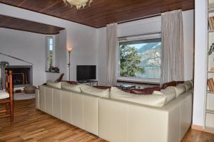 una sala de estar con un gran sofá blanco y una ventana en Villa Perledina by Wonderful Italy en Perledo